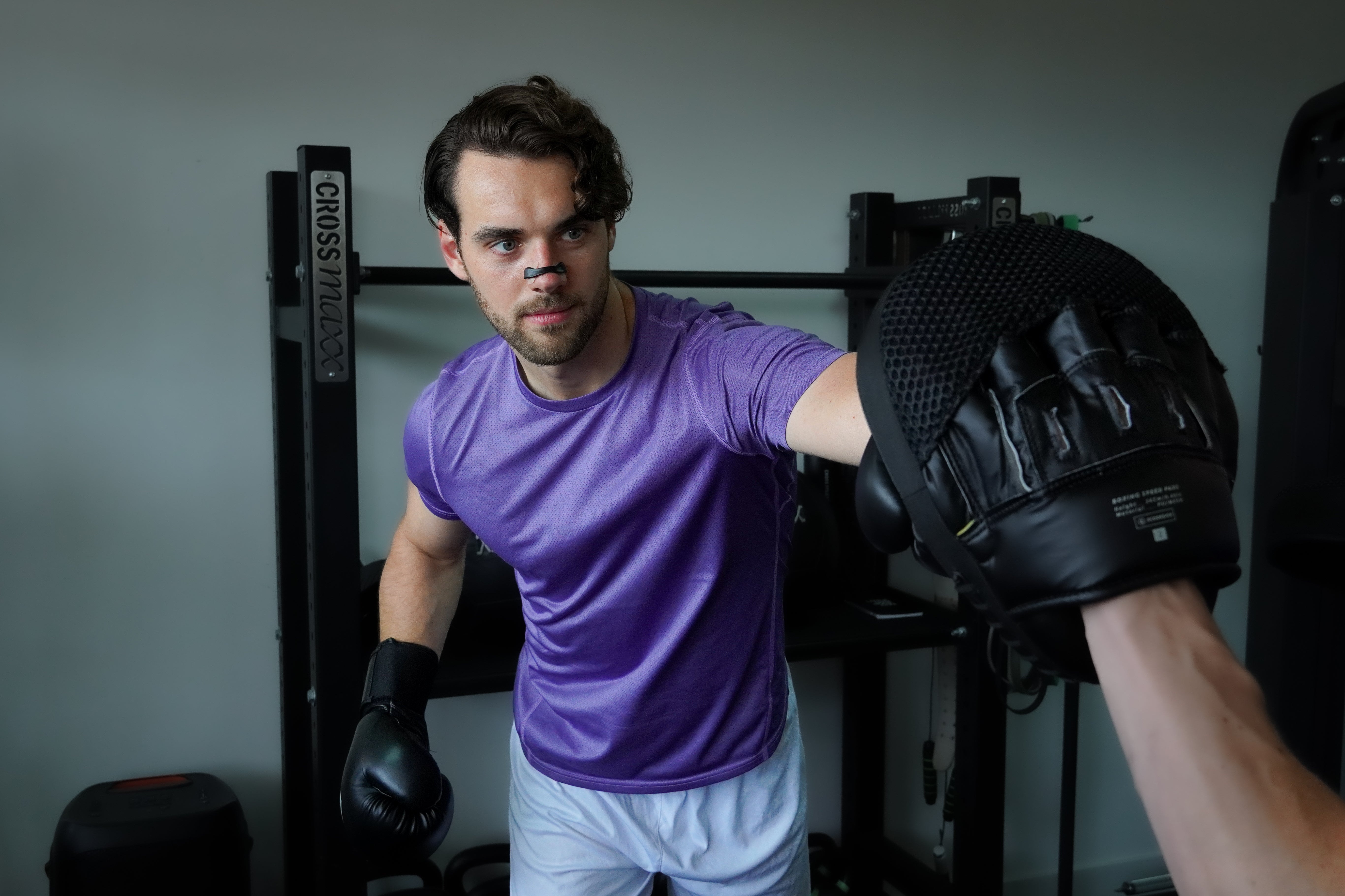 Man gebruikt zwarte magnetische neusstrips van Breathe Boosters tijdens het sporten